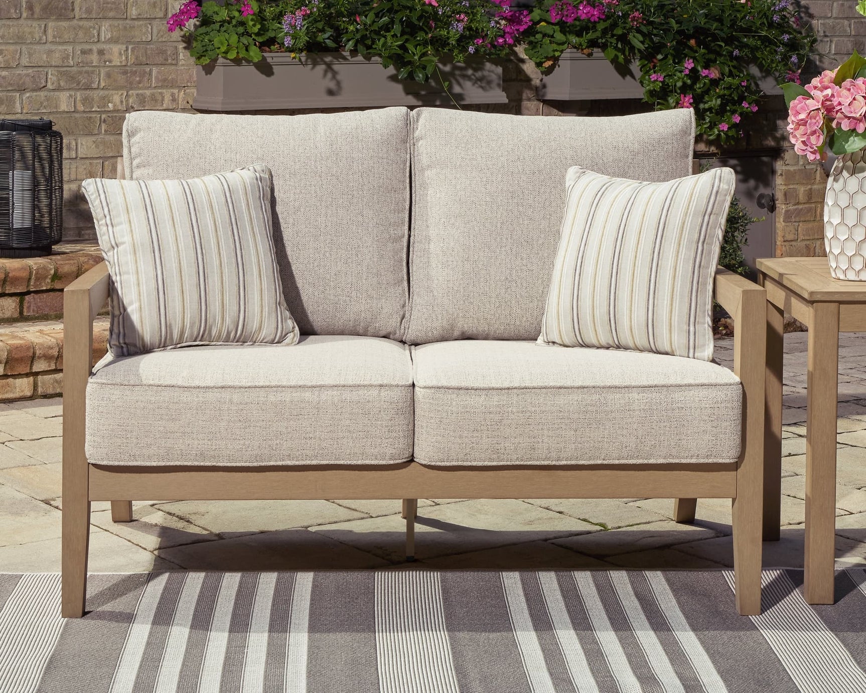 Hallow Creek Driftwood Outdoor Loveseat front angle showing cushions