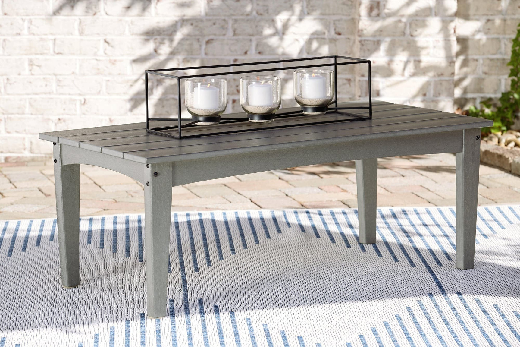 Visola Gray Outdoor Coffee Table angled view showing slatted tabletop and lower shelf