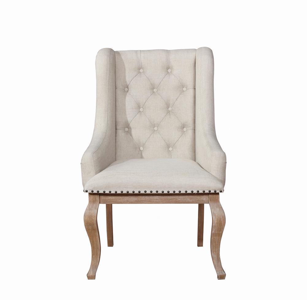 Close-up of diamond button tufting and nailhead trim on armchair back