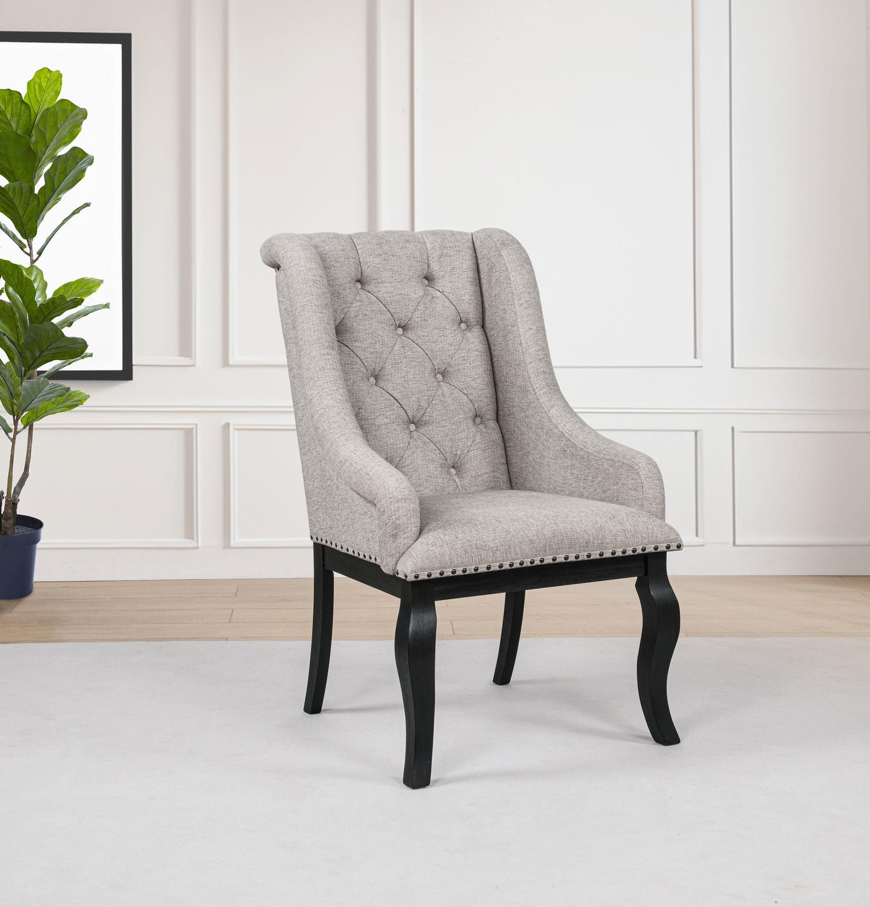 Side angle of Phelps Upholstered Dining Arm Chair highlighting bronze nailhead trim