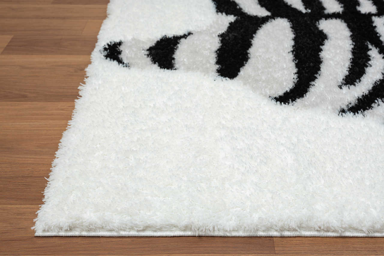 Black and white shag rug style displayed on wood floor