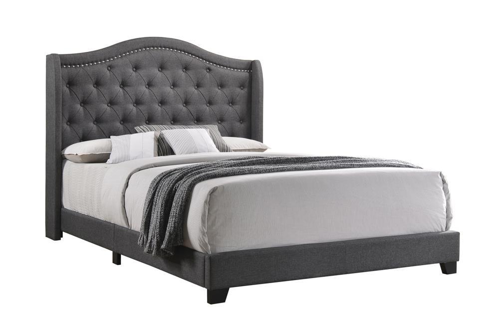 Side view showing tufted grey fabric and side storage drawers