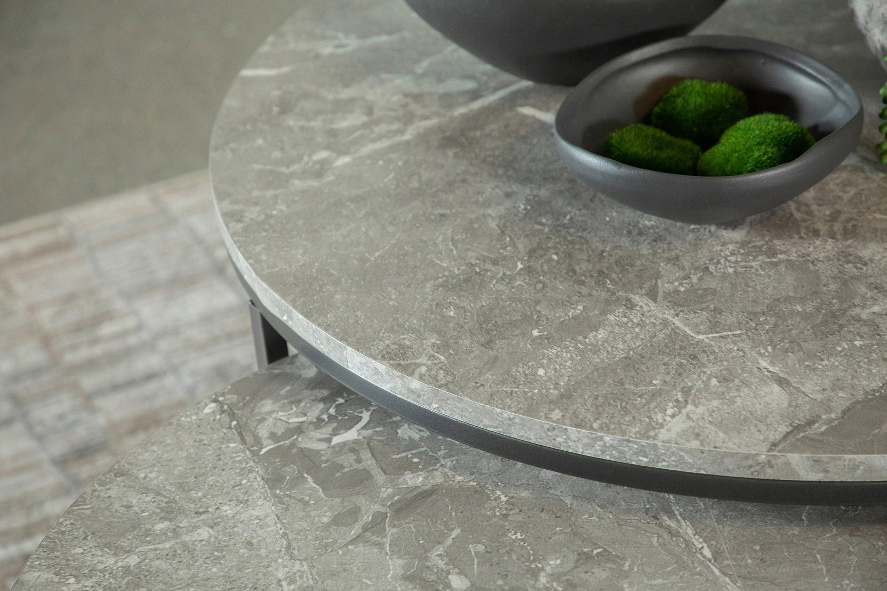 Close-up of gunmetal metal frame and faux marble tabletop