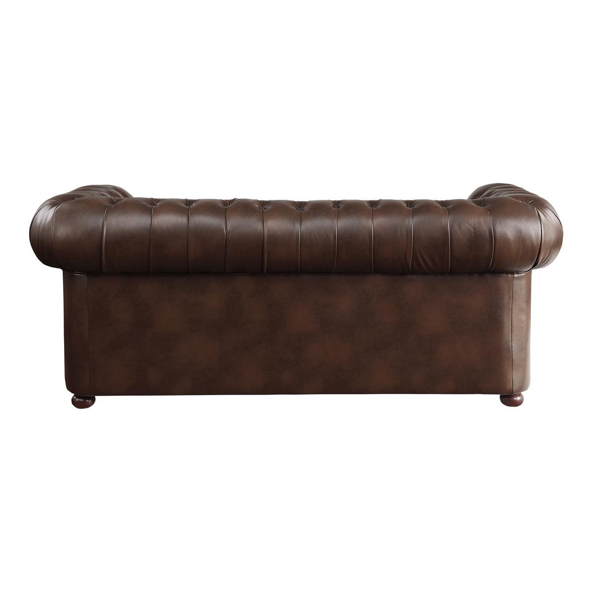 Detail of tufted brown faux leather upholstery on sofa