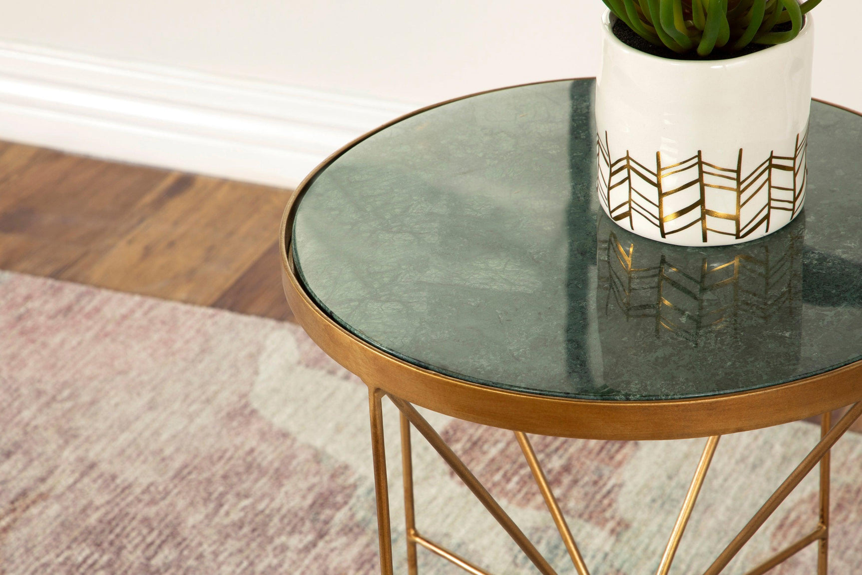 Side view of Eliska round accent table highlighting teardrop feet and marble surface