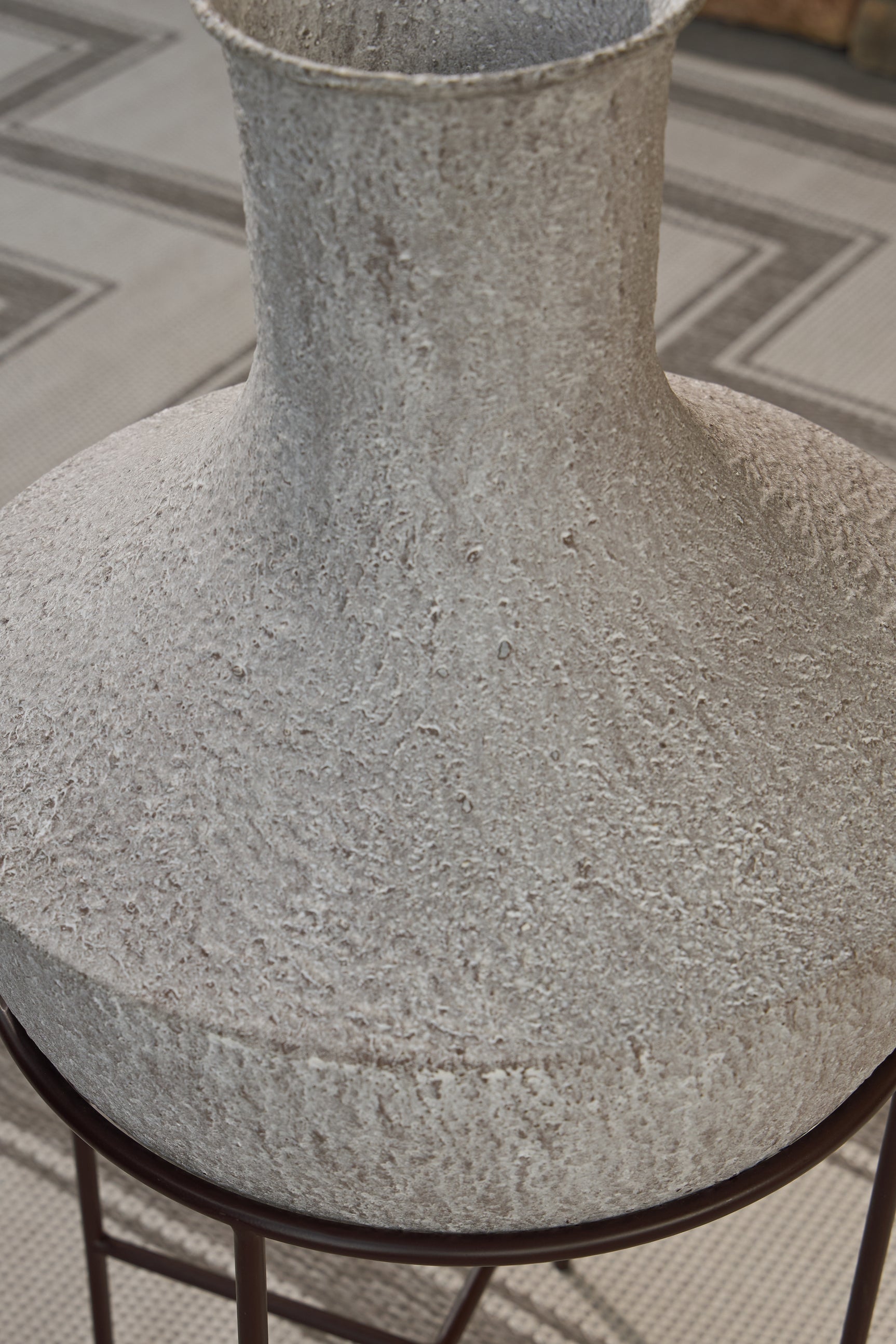Espresso brown metal stand supporting the Estonbank Vase