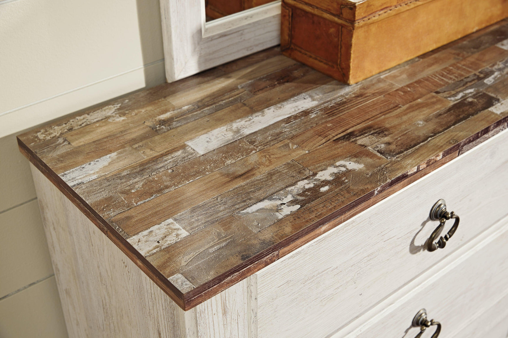 Close-up of antiqued brass-tone ring-pull hardware and whitewashed finish