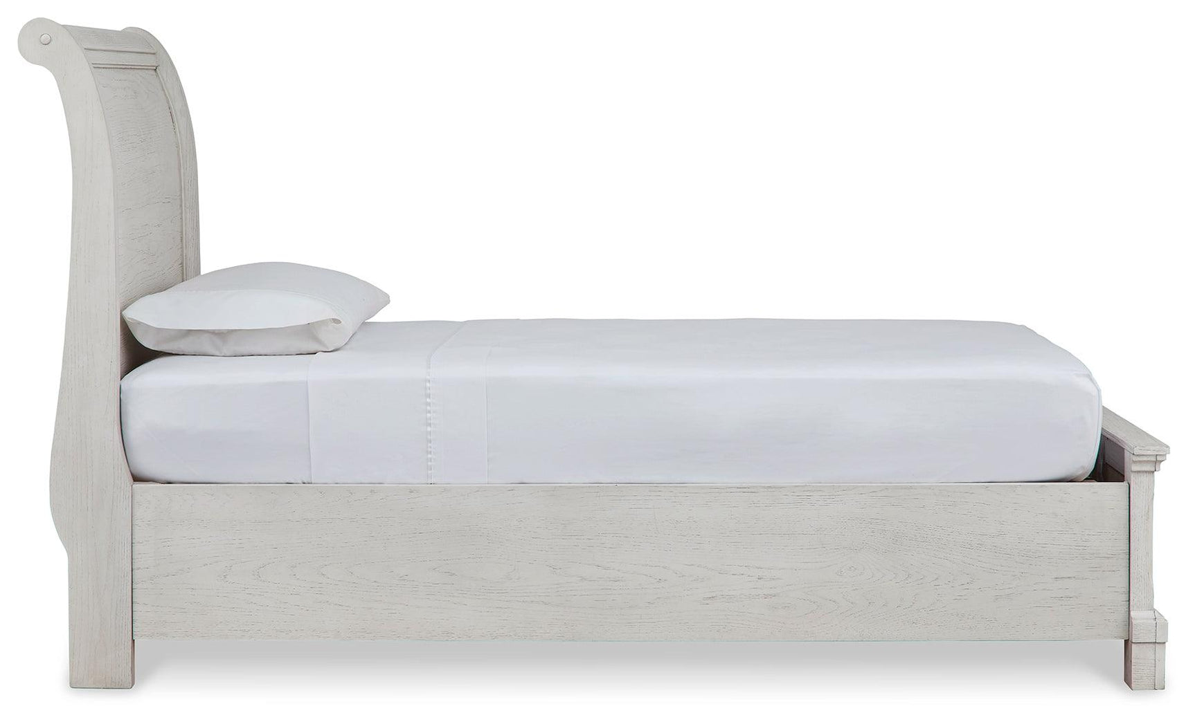 Side profile of antique white twin sleigh bed showing footboard detail