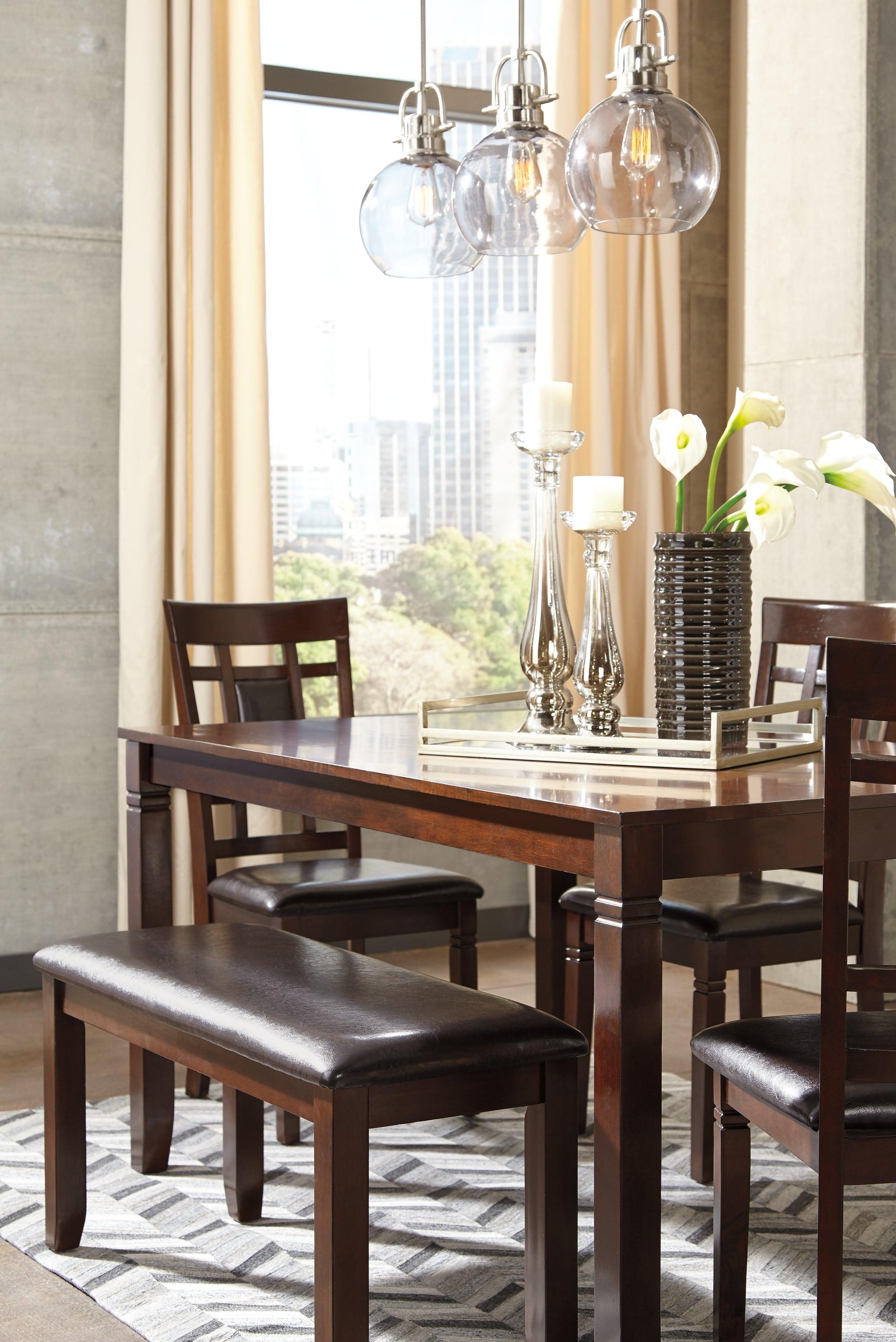 Dining room setup with Bennox brown table, chairs, and bench