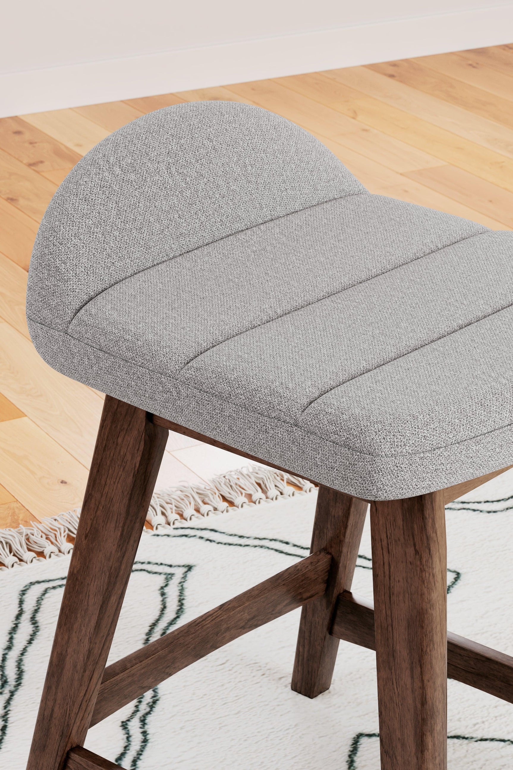 Detail of upholstery and wood frame junction on Lyncott bar stool