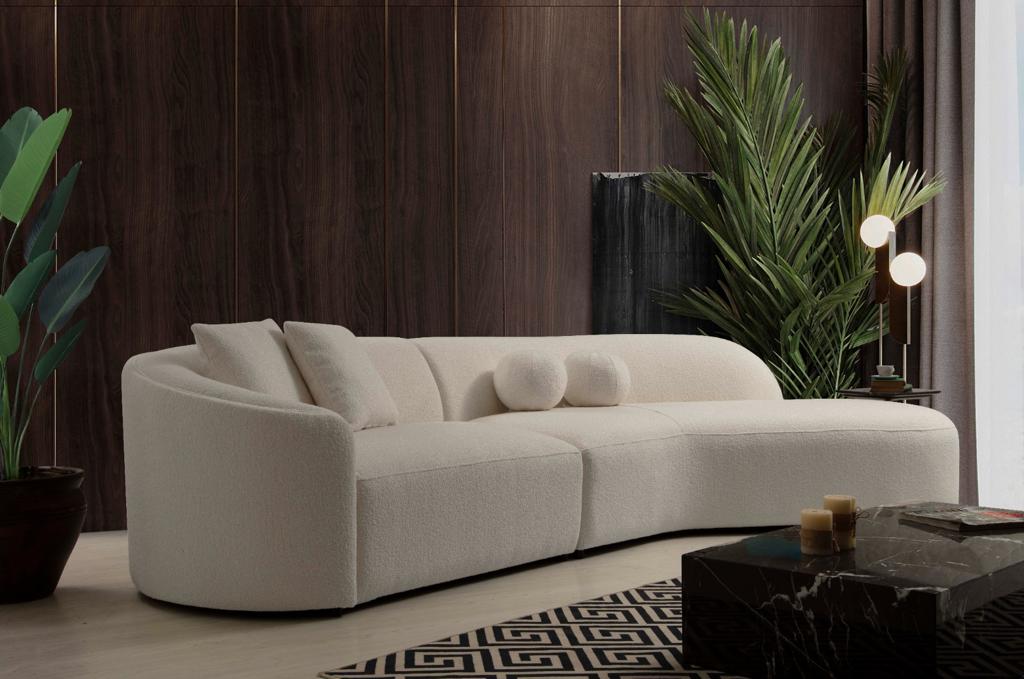 Room setting featuring Ava Ivory Boucle Curved 134" RAF Sectional sofa