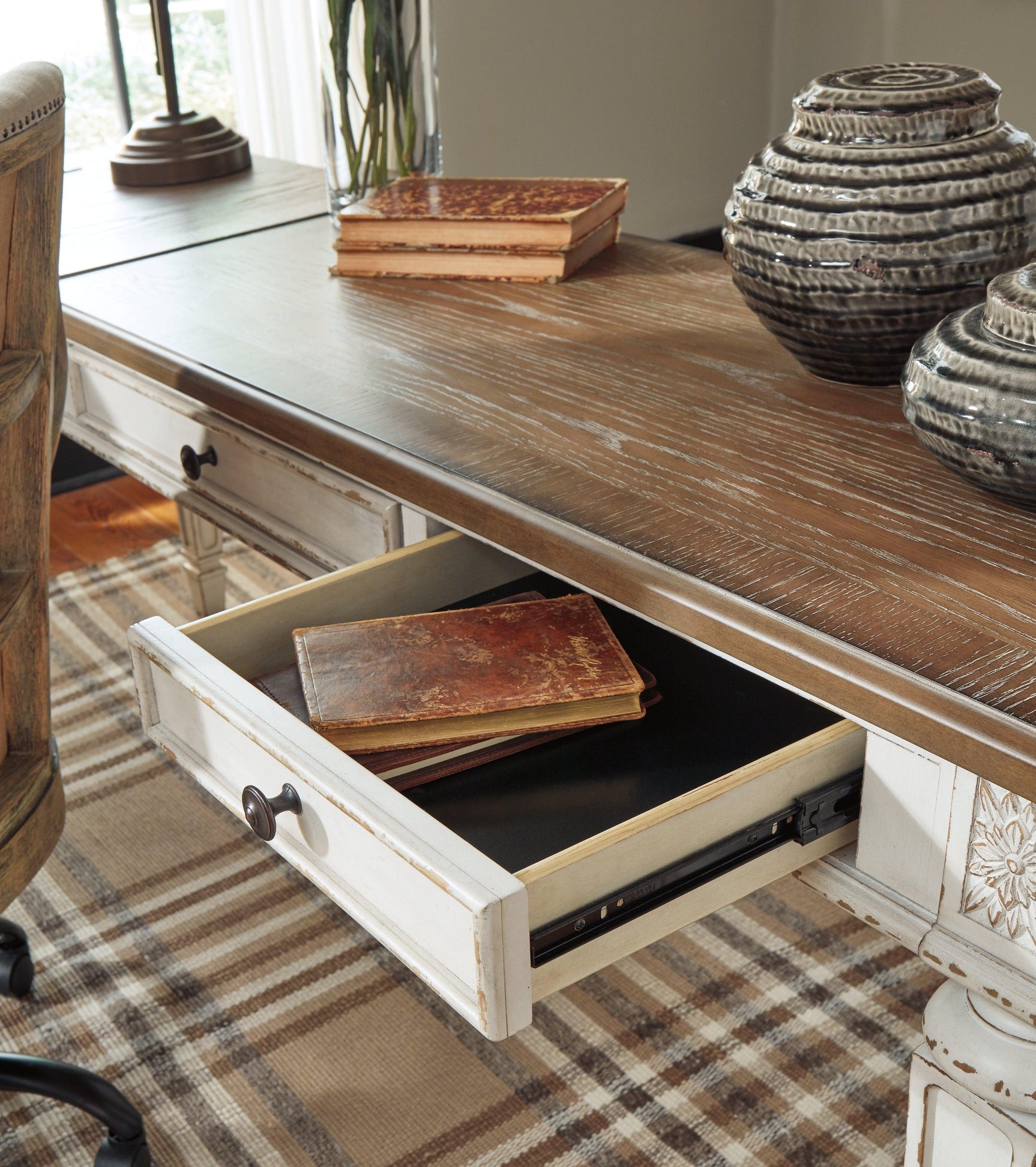 Close-up of Realyn desk dark bronze drawer handle