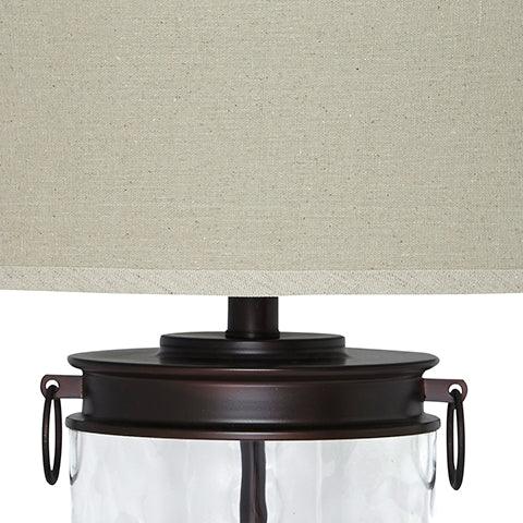 Close-up of Tailynn table lamp bronze finish and clear glass base