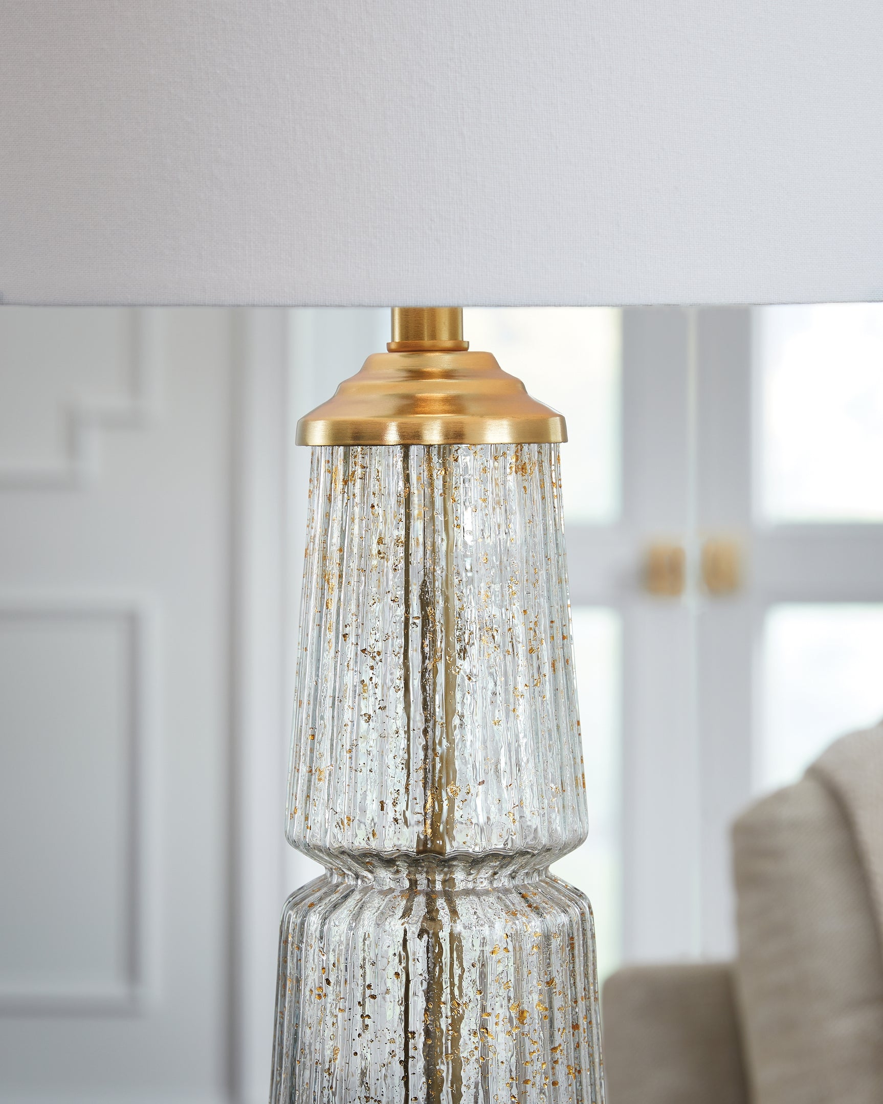 Close-up of clear fluted glass with gold flecks on lamp base