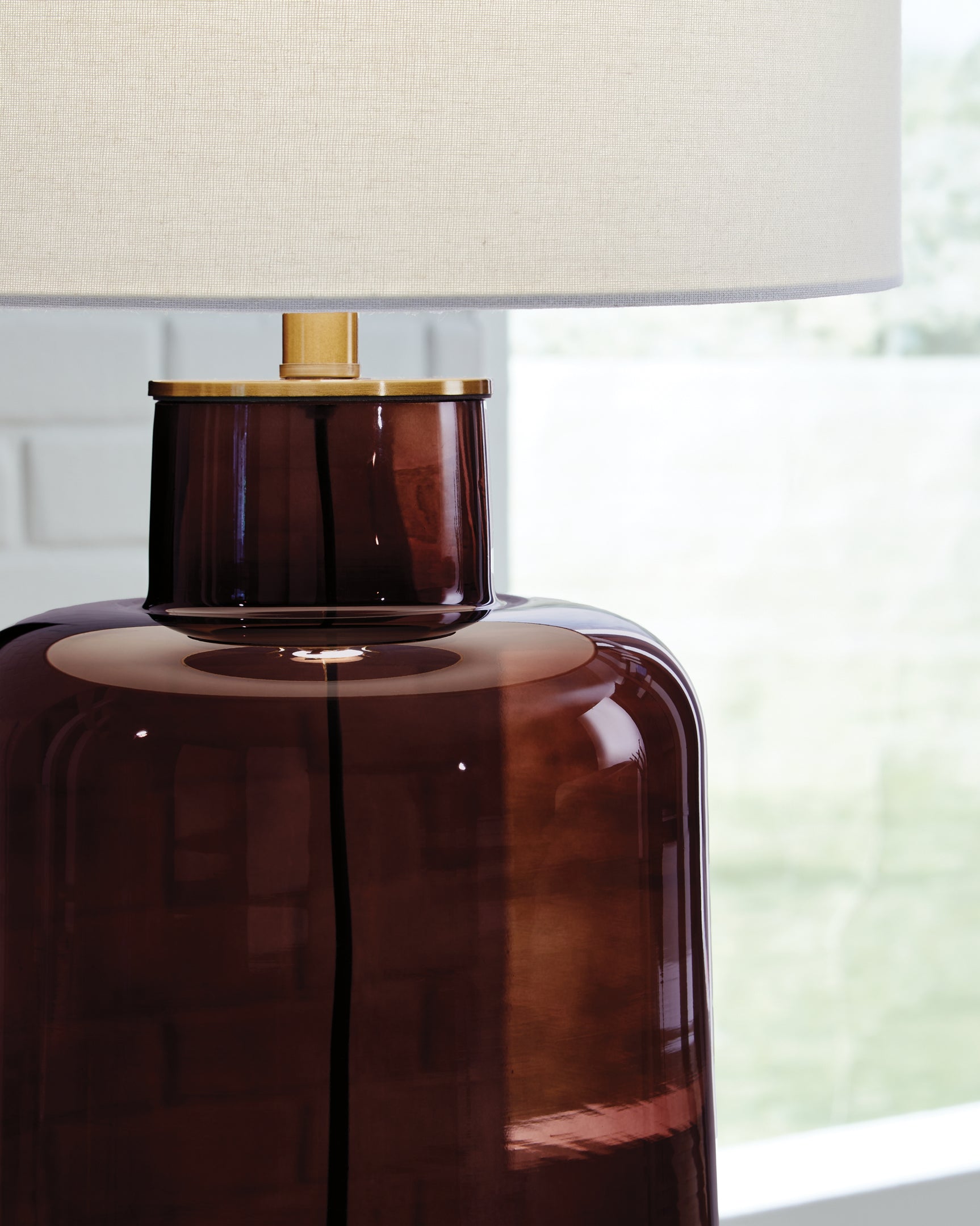 Close-up of goldtone metal accents and glass base on Mette table lamp