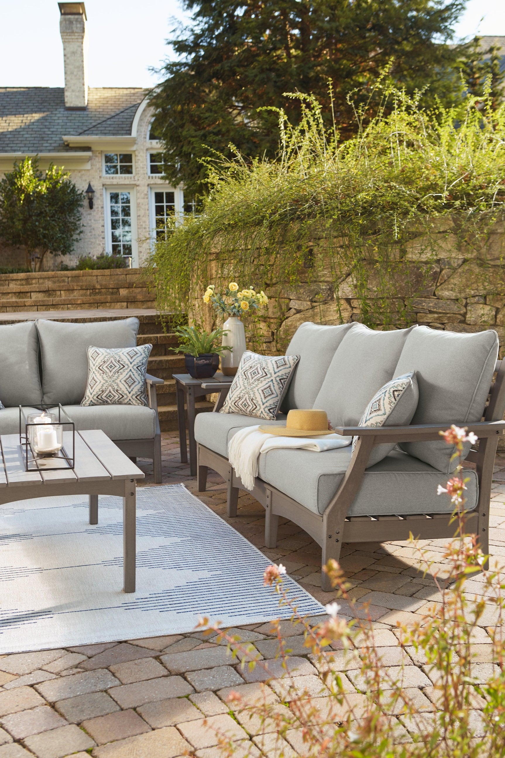 Visola Gray Outdoor Sofa with cushions lifestyle setting vertical
