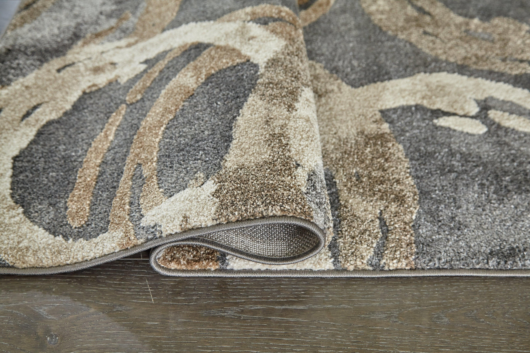 Rolled view of Faelyn Multi 5' x 7'3" area rug showing thickness and backing