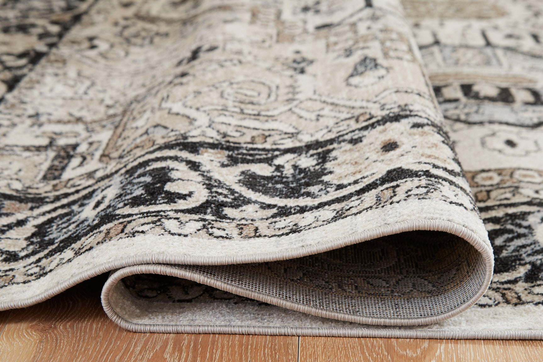 Rolled Gregmoore Multi 5'2" x 6'10" rug showing thickness and pattern