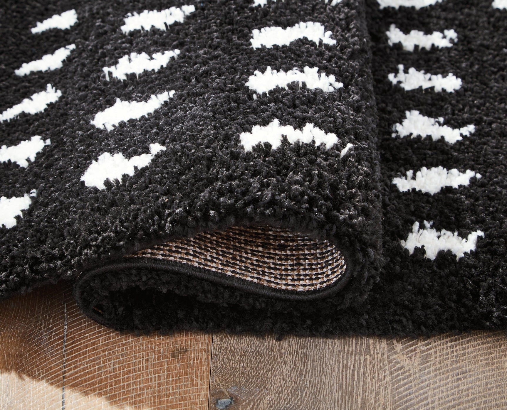 Rolled Minston black and white area rug showing texture