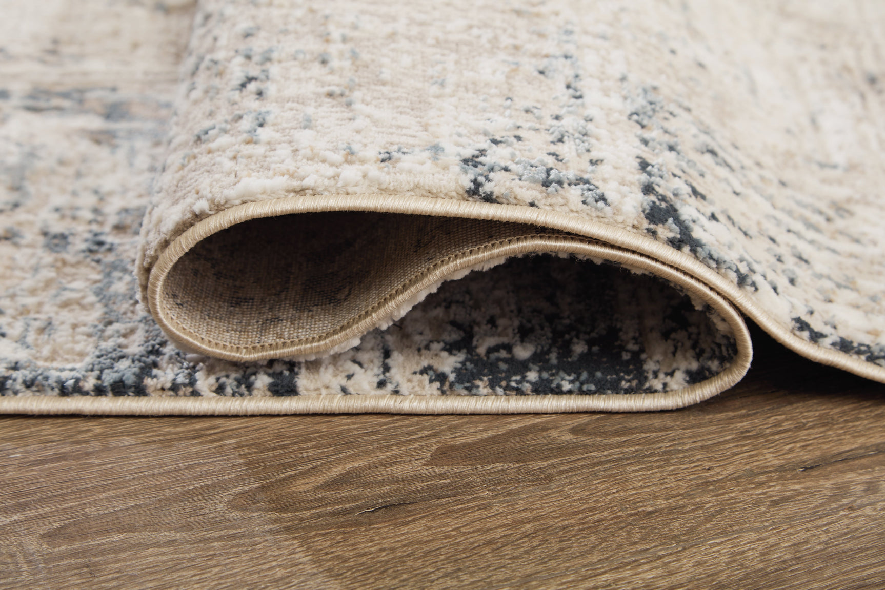 Rolled Gentor rug showing blue and ivory colors