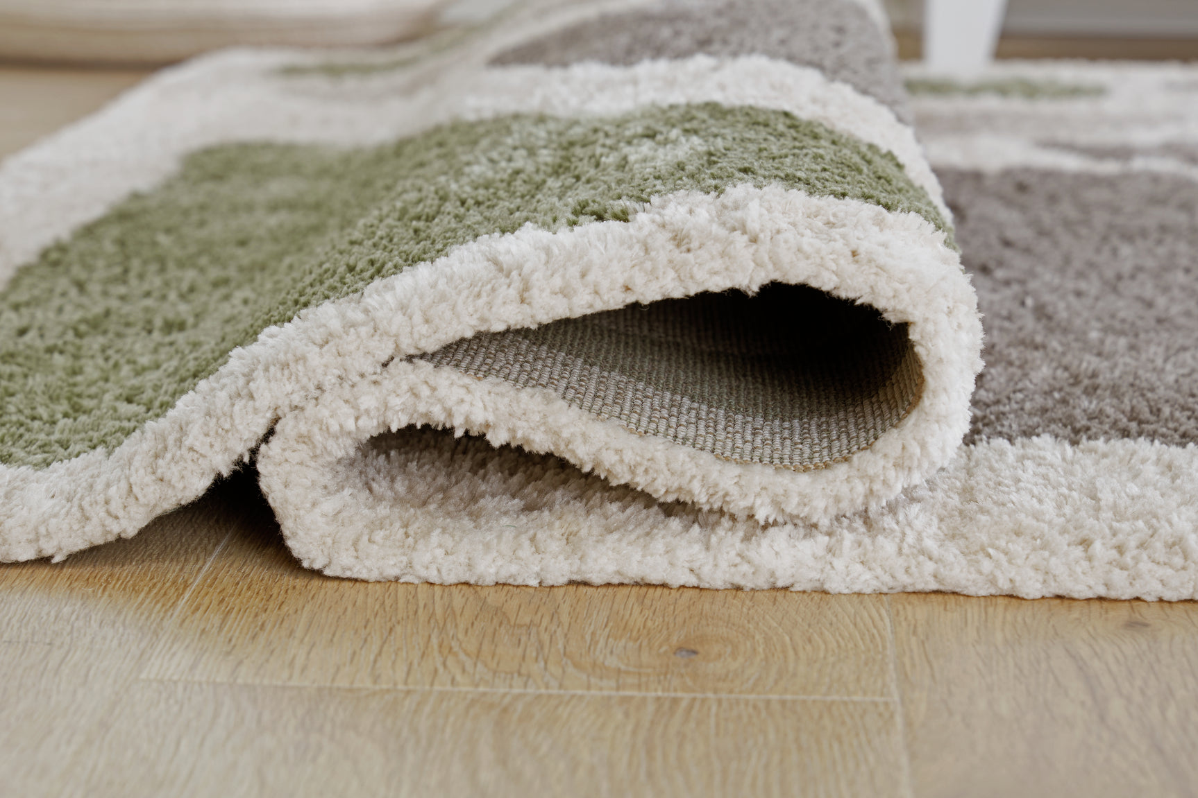 Rolled edge detail of Anburgh green gray ivory rug