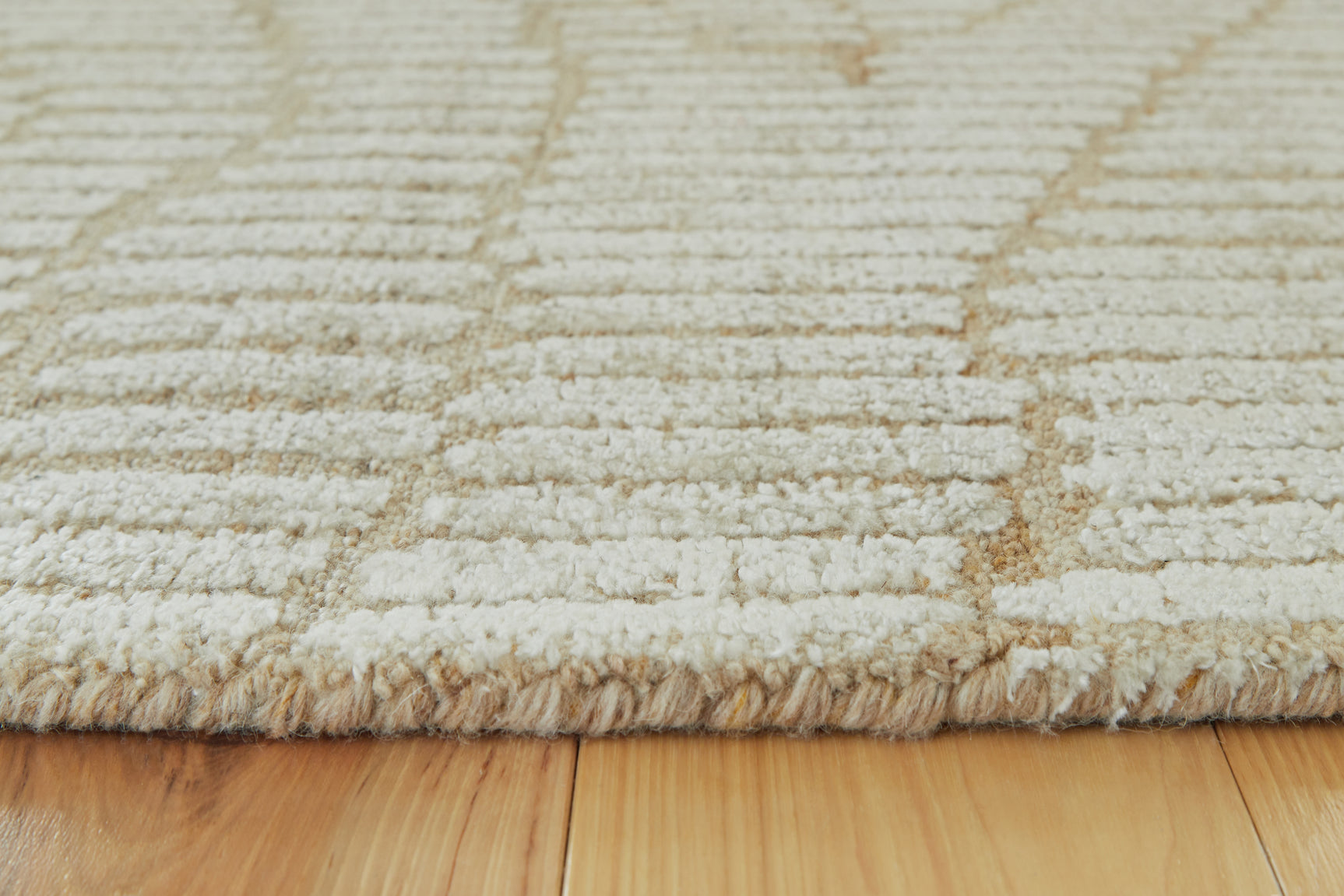 Rolled edge detail of Jaseena beige and tan area rug