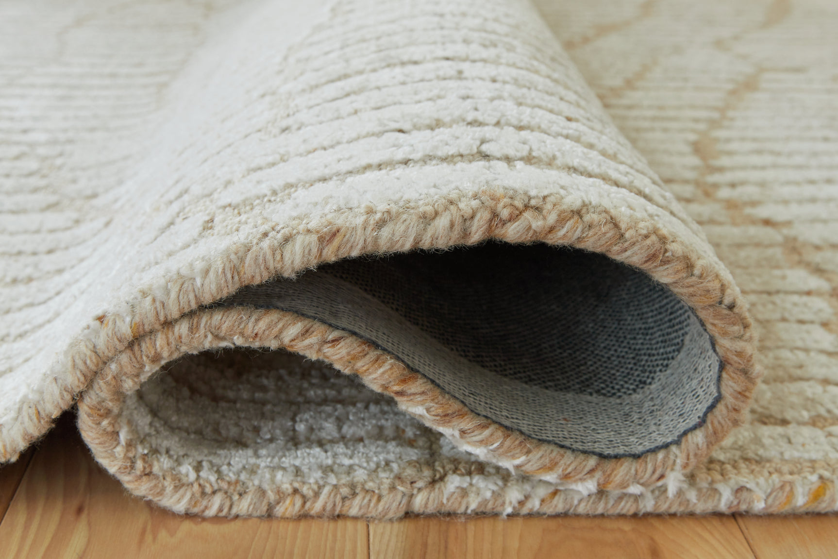 Rolled edge detail of Jaseena beige and tan area rug