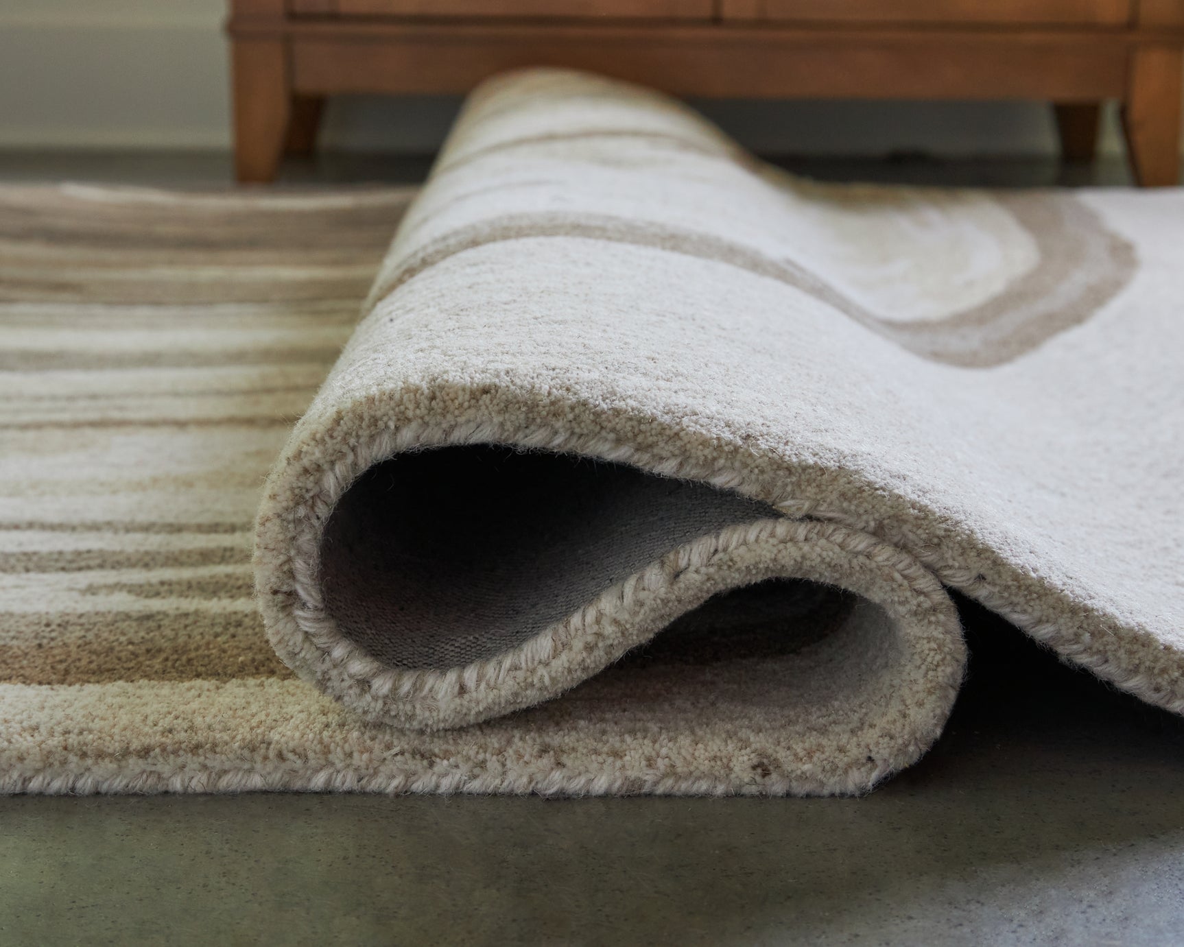Rolled Rizwana rug showing wool texture detail