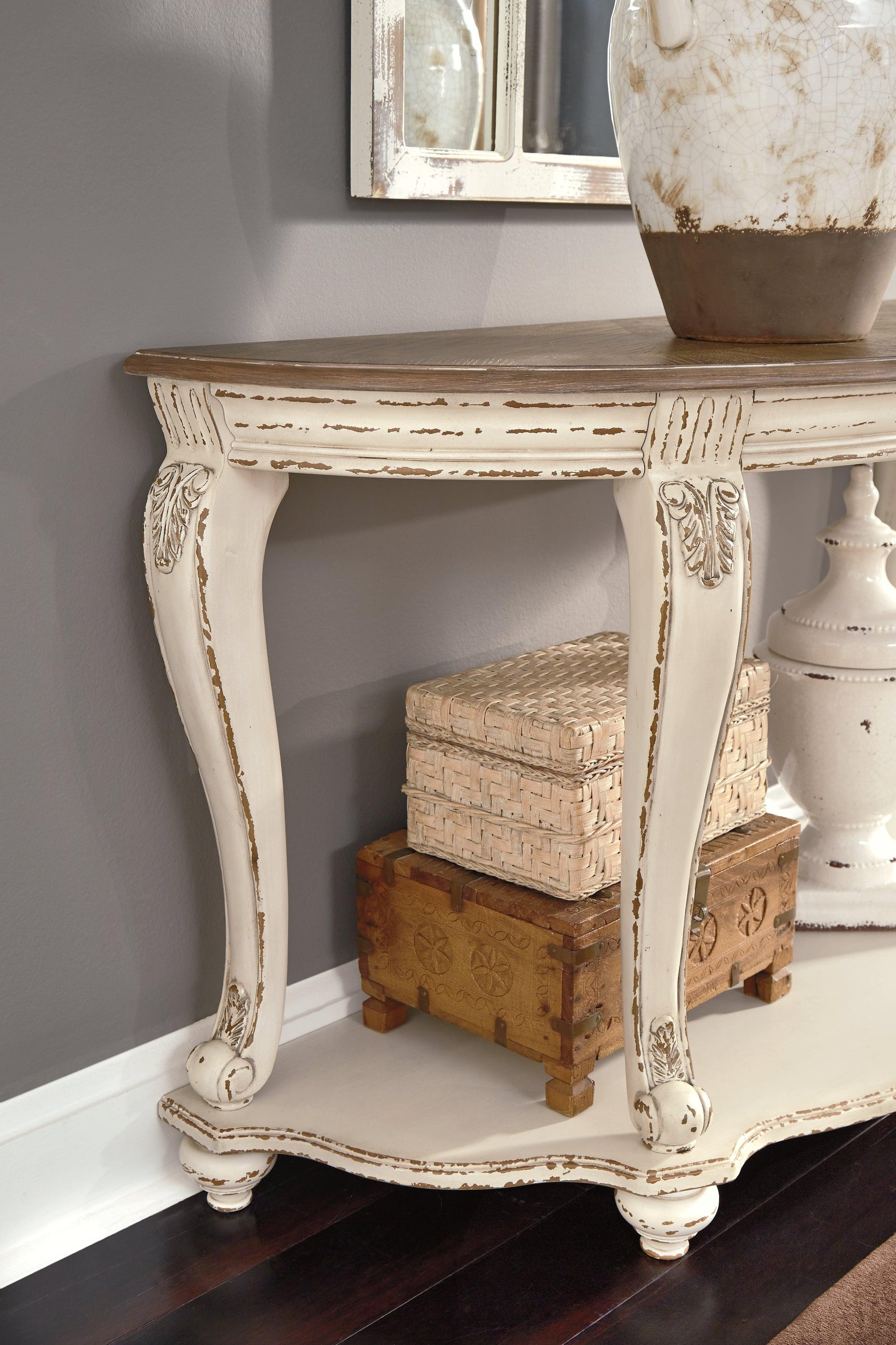 Close-up of Realyn sofa table distressed brown top and drawer hardware
