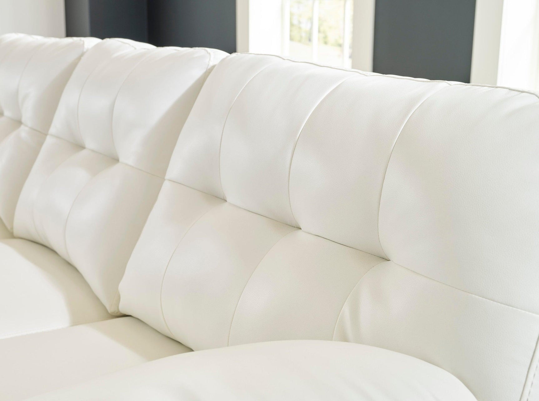 Side perspective of Ashley RAF Chaise sectional sofa with white legs