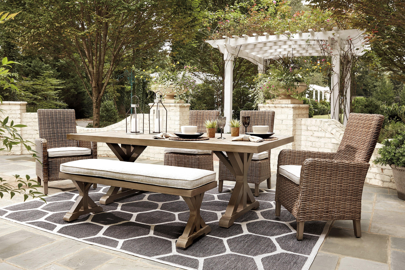 Set of 4 resin wicker chairs and bench with beige Nuvella cushions around Beachcroft dining table