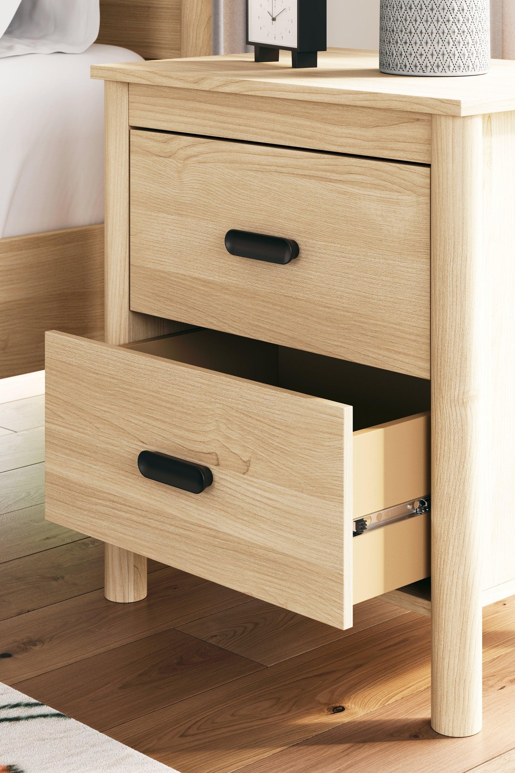 Nightstand with drawers partially open showing vinyl-wrapped sides