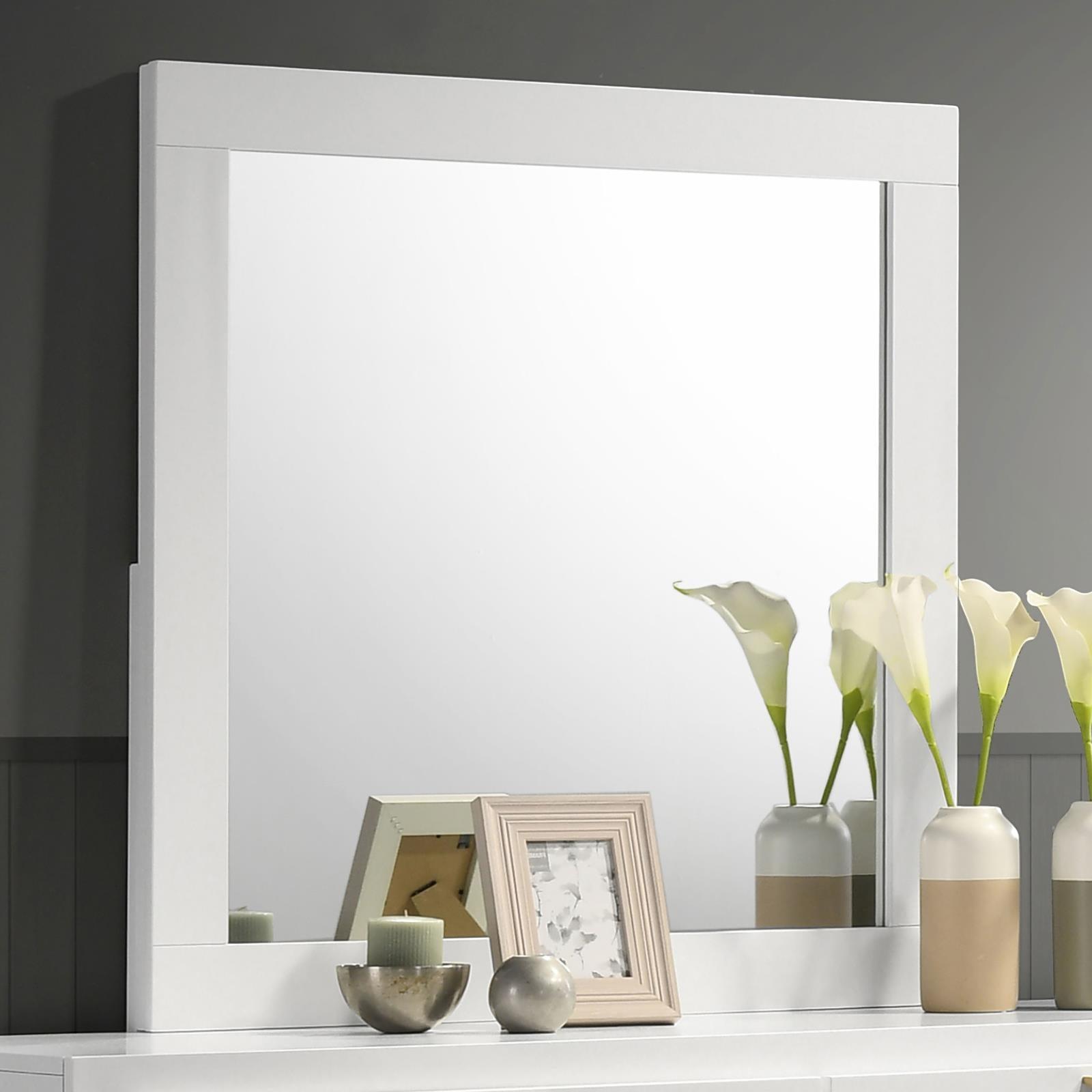 White framed dresser mirror hanging over dresser