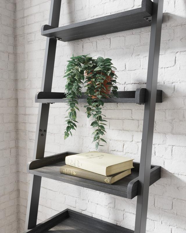 Close-up of dark wood grain shelves and black metal frame of Yarlow leaning ladder bookcase