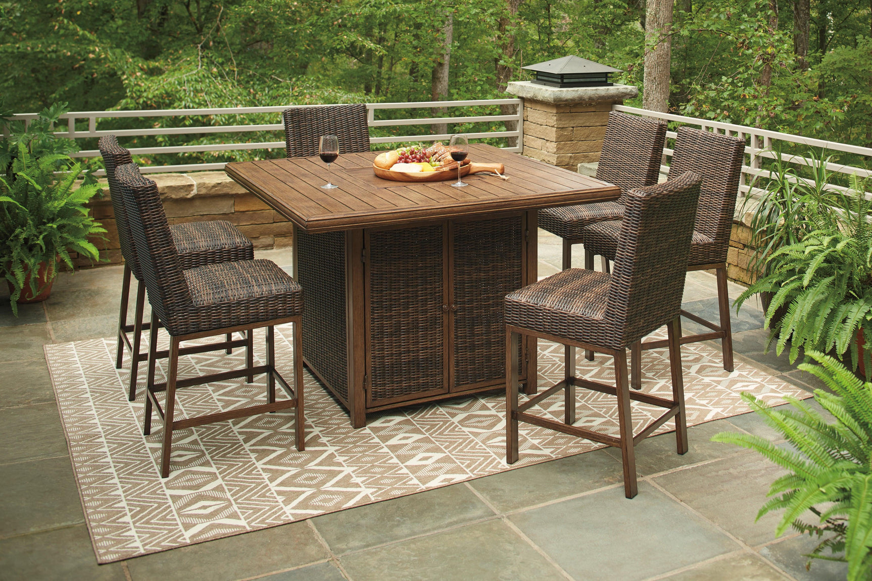 Medium Brown outdoor bar table and bar stools set on patio