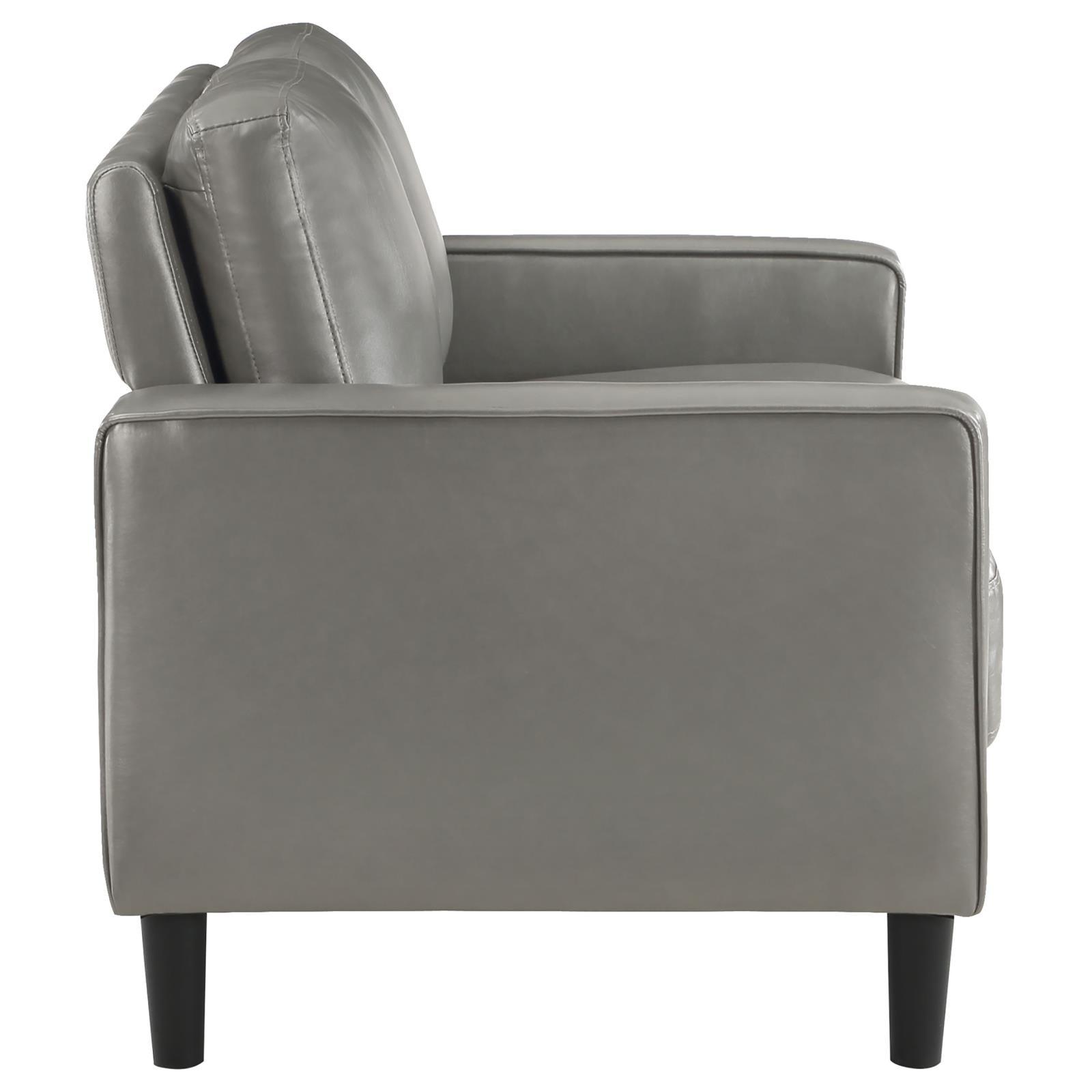 Detailed view of loveseat arm with faux leather texture