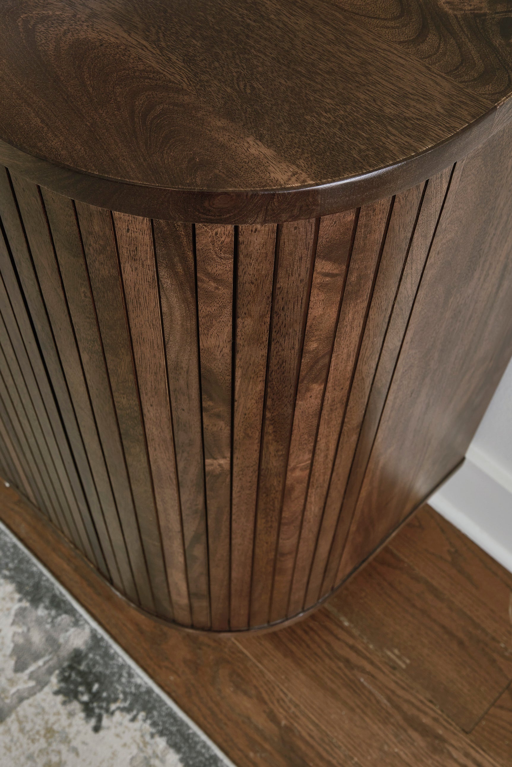 Goldtone metal base supporting the mango wood cabinet