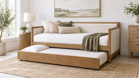 Neutral bright bedroom with a wooden frame daybed featuring a pull-out trundle and light upholstery