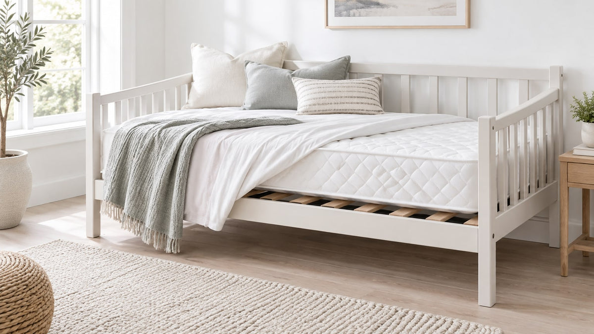Bright white bedroom featuring a stylish daybed with twin mattress and pull-out trundle in a neutral setting
