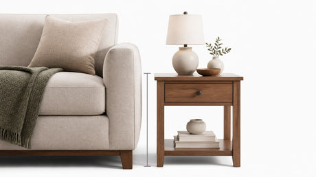 Stylish modern end table positioned next to a sofa in a clean white studio setting