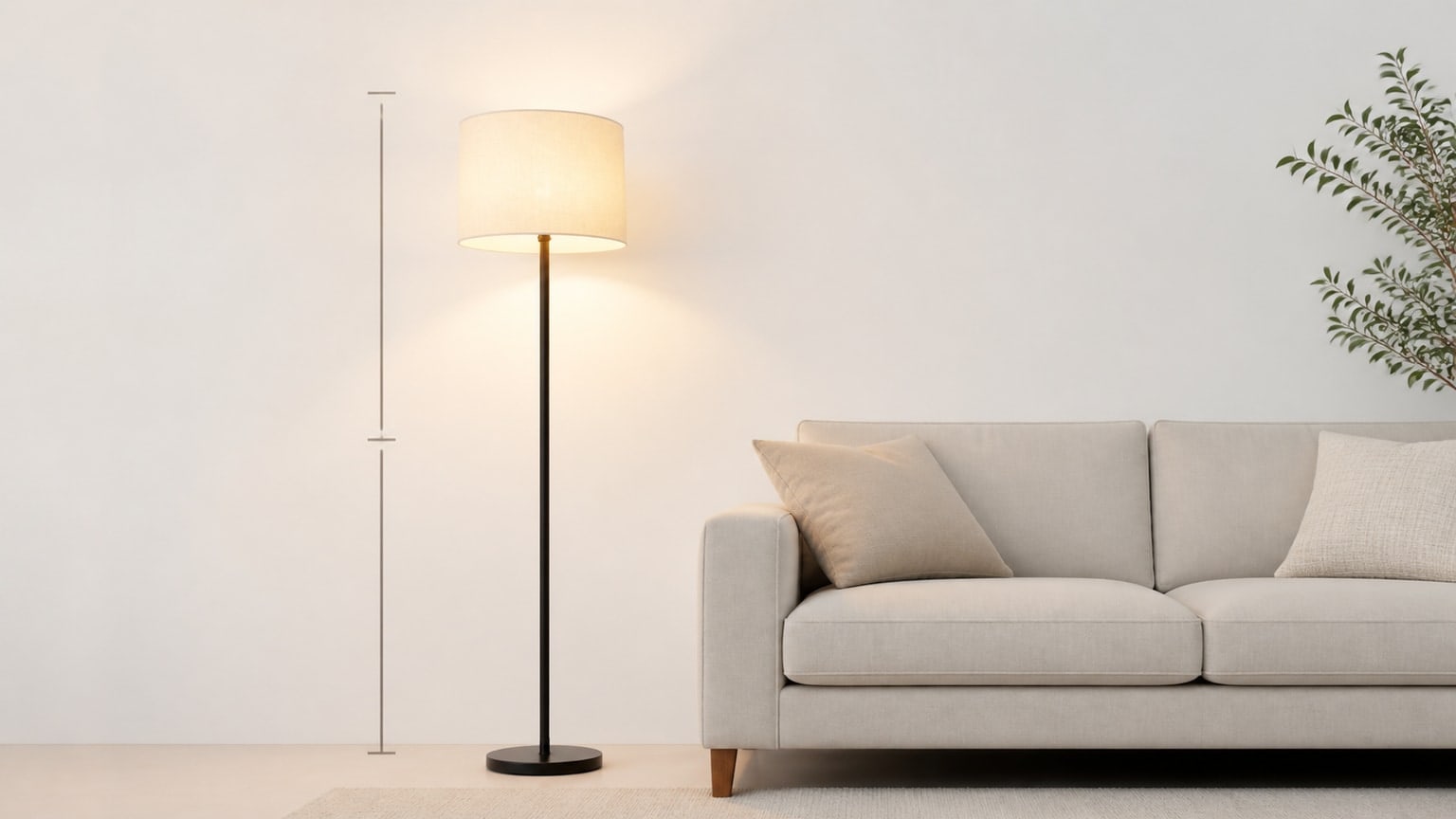 Modern floor lamp with drum shade on clean white background, softly lit with warm neutral glow