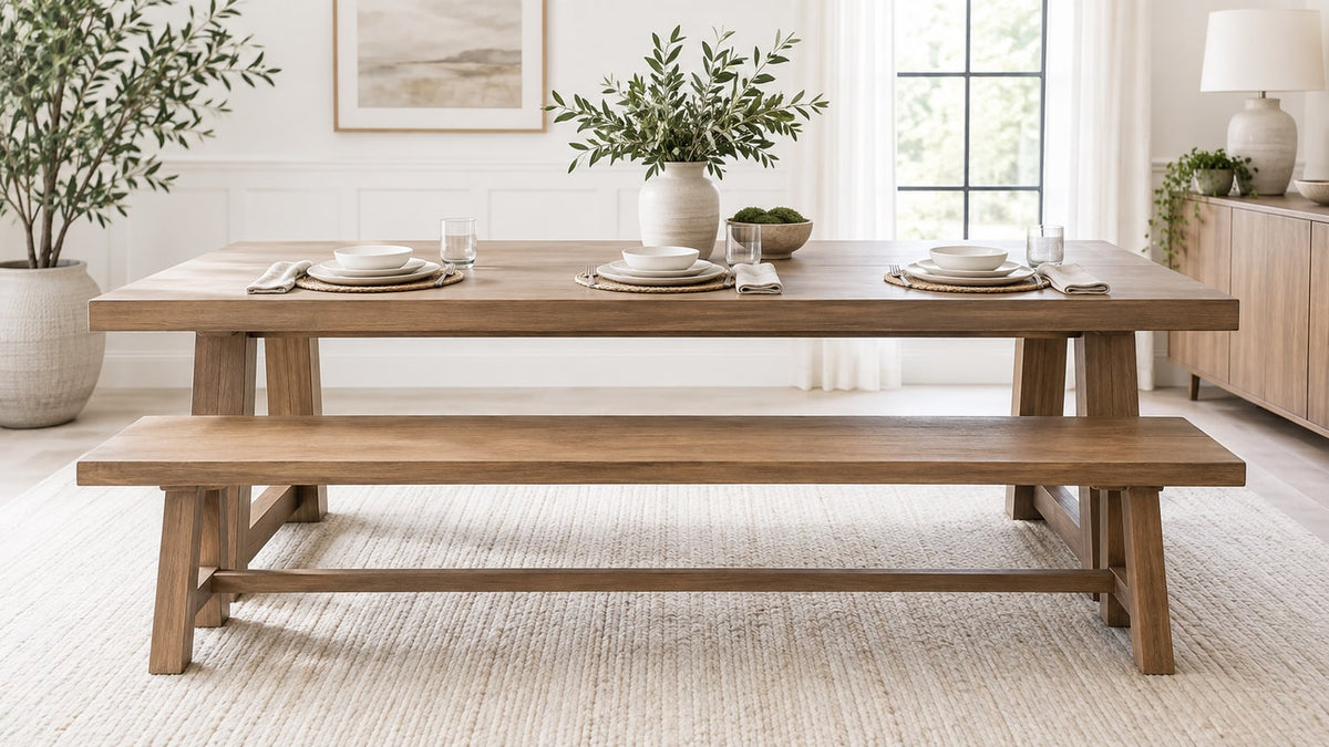 Modern dining room with wooden dining bench and matching dining table and chairs in bright neutral interior.