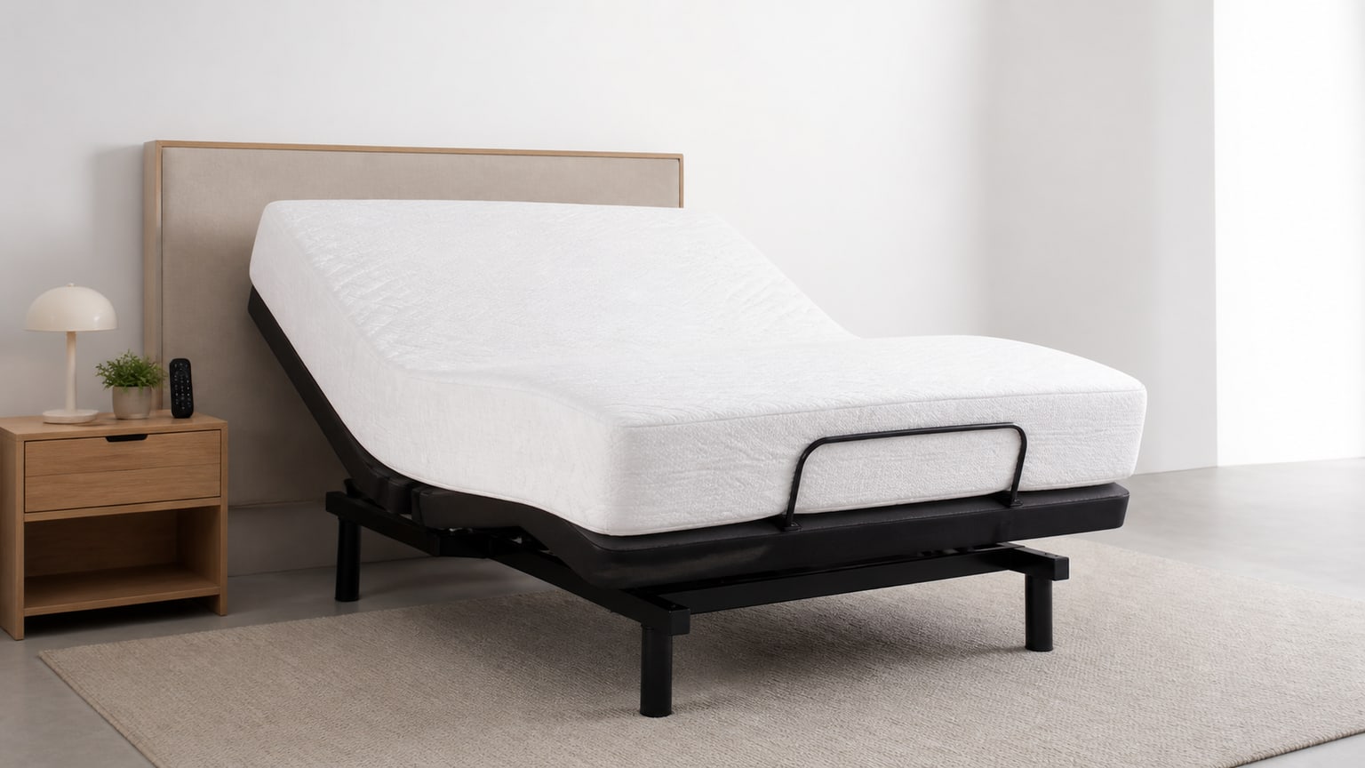 Adjustable bed base with mattress and remote on white background