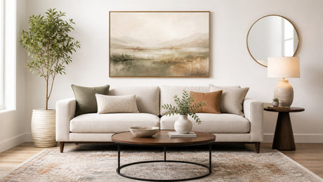 Living room interior showcasing neutral sofa with coordinated framed and canvas wall art on white background