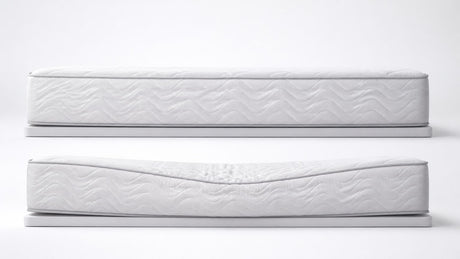 Studio image of a high-quality mattress showing smooth surface and layers, on simple bed frame against white background.