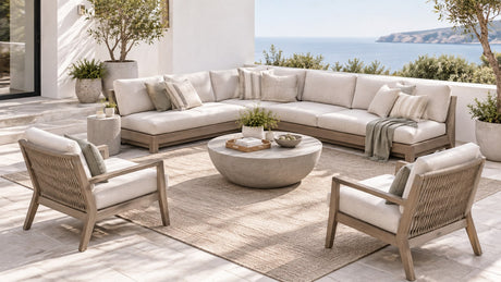 Modern outdoor sectional patio set with an L-shaped wicker sectional, coffee table, outdoor rug, and umbrella on a bright white background