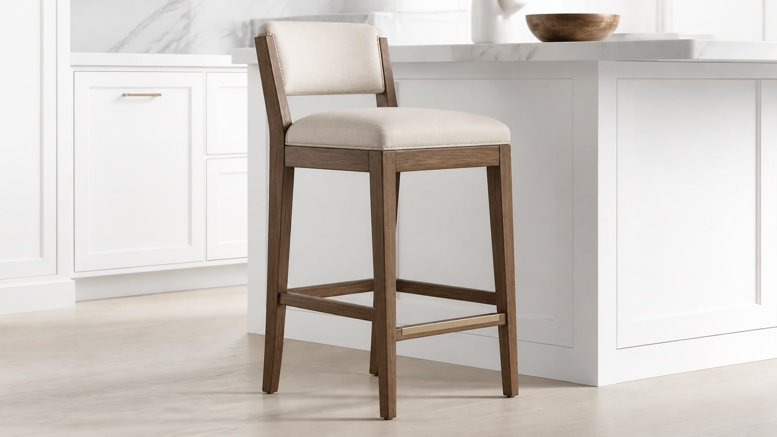 Quality wooden bar stool with upholstered seat and swivel next to white kitchen island