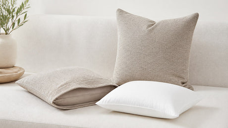 Grouped throw pillows with covers and inserts showcasing different sizes and textures on sofa and bed against white background