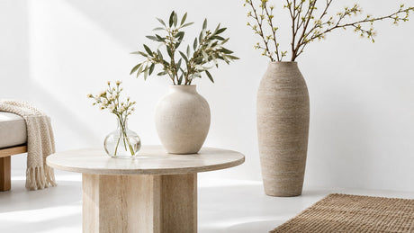 Various vases and decorative accessories styled on a bright neutral surface