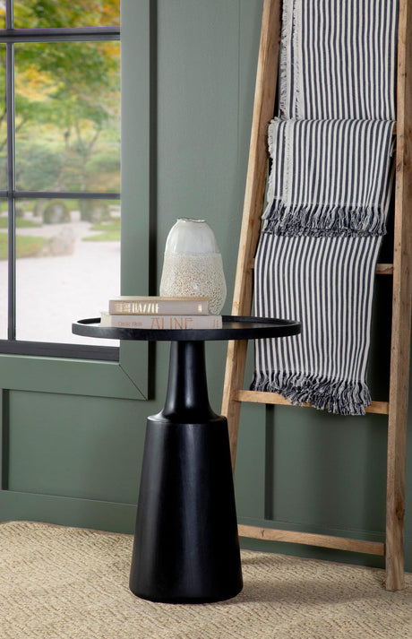 Ixia Round Mango Wood Accent Table with black tabletop and contoured base, angled view